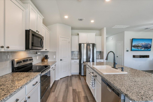 kitchen with a sink, appliances with stainless steel finishes, white cabinets, dark wood-style flooring, and visible vents