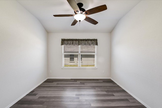 spare room featuring wood finished floors, lofted ceiling, baseboards, and ceiling fan