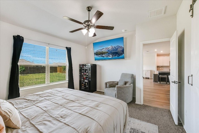 bedroom with carpet flooring, vaulted ceiling, baseboards, visible vents, and ceiling fan