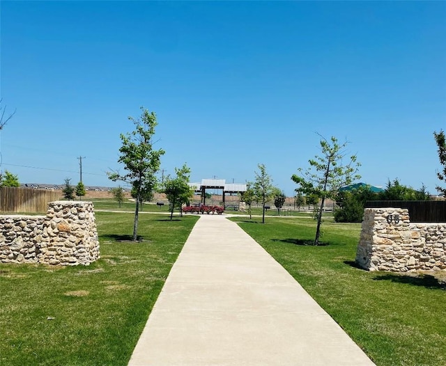 view of community featuring fence, a lawn, and a gazebo