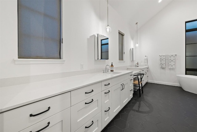 308 Rustling Wake Cv, Lakeway, TX 78738 - full bathroom featuring vanity, lofted ceiling, a freestanding tub, and tile patterned floors