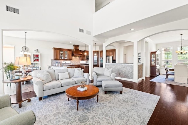 16216 Zagros Way, Austin, TX 78738 - living area featuring a chandelier, dark wood-style floors, arched walkways, and recessed lighting