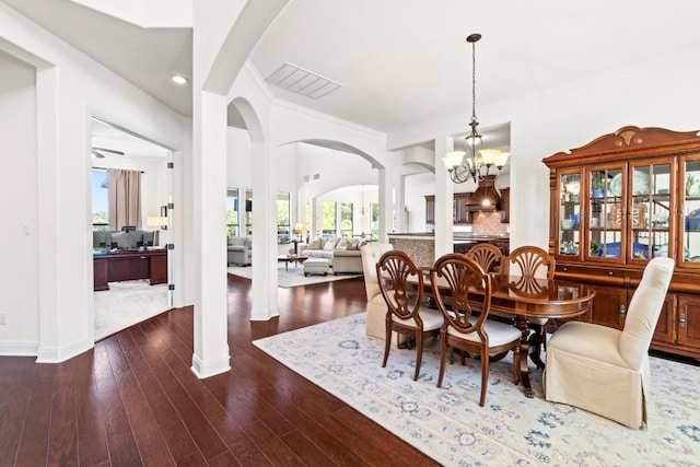 16216 Zagros Way, Austin, TX 78738 - dining area with arched walkways, a chandelier, dark wood-style floors, ornamental molding, and recessed lighting