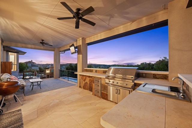 16216 Zagros Way, Austin, TX 78738 - patio terrace at dusk featuring an outdoor kitchen, ceiling fan, and a patio