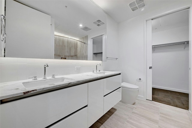 313 W 17th St Unit 2406, Austin, TX 78701 - bathroom featuring visible vents, a sink, a walk in closet, and toilet