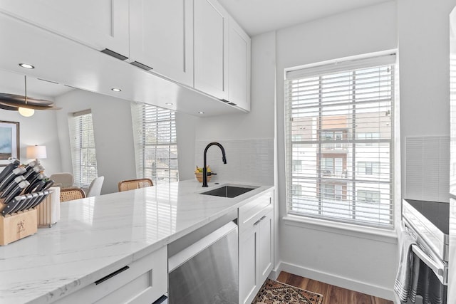 kitchen with white cabinets, a healthy amount of sunlight, stainless steel dishwasher, and a sink