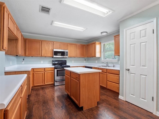 1415 Quicksilver Cir, Round Rock, TX 78665 - kitchen featuring appliances with stainless steel finishes, a sink, ornamental molding, dark wood-type flooring, and light countertops
