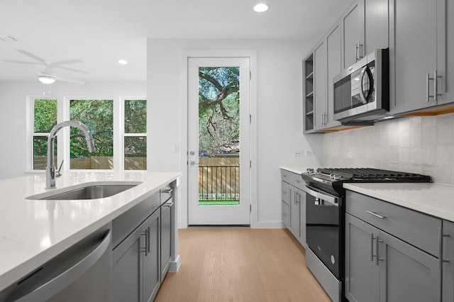 5107 Menchaca Rd Unit 9, Austin, TX 78745 - kitchen featuring stainless steel appliances, gray cabinets, light wood finished floors, light countertops, and recessed lighting
