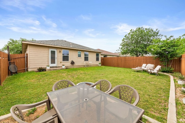 12616 Sky Harbor Dr, Del Valle, TX 78617 - rear view of house with a fenced backyard, an outdoor hangout area, entry steps, outdoor dining area, and a lawn