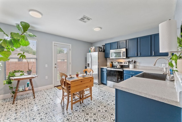 12616 Sky Harbor Dr, Del Valle, TX 78617 - kitchen with stainless steel appliances, a sink, visible vents, blue cabinetry, and light countertops
