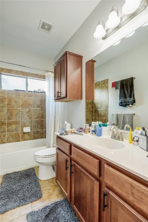 bathroom with vanity, shower / bath combination with curtain, toilet, tile patterned flooring, and visible vents