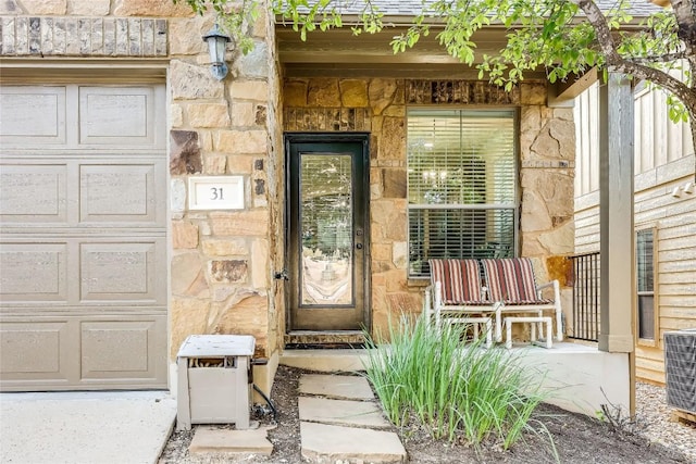 view of exterior entry featuring central air condition unit, a porch, and stone siding