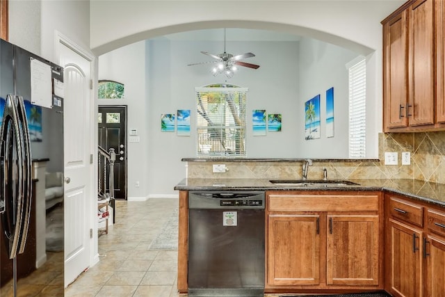 kitchen featuring dishwasher, a ceiling fan, a sink, freestanding refrigerator, and a peninsula