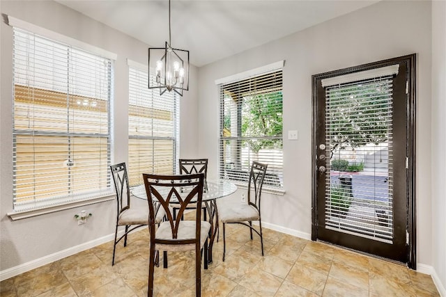 dining room with a chandelier and baseboards