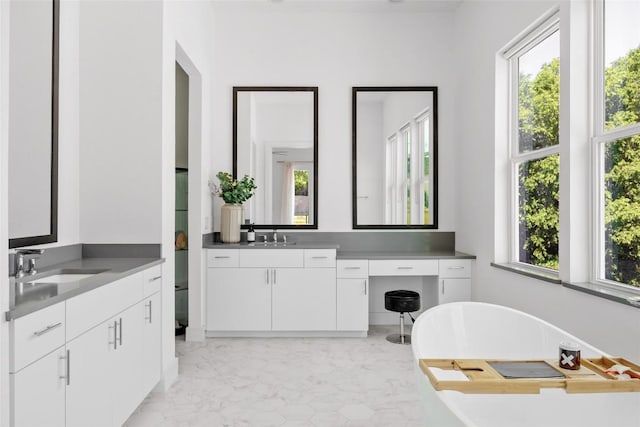 5368 Agatha Cir, Austin, TX 78724 - full bathroom featuring two vanities, healthy amount of natural light, a freestanding bath, and marble look tile flooring