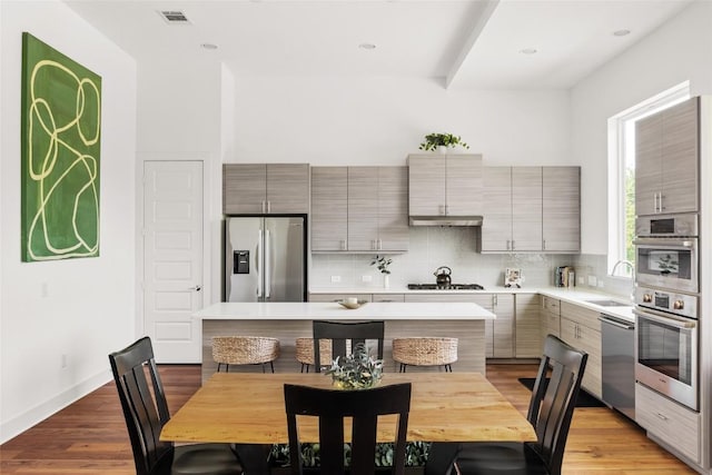 5368 Agatha Cir, Austin, TX 78724 - kitchen featuring appliances with stainless steel finishes, a sink, tasteful backsplash, light countertops, and a kitchen island