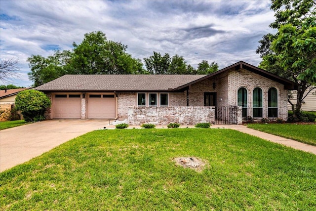 9011 W Pointer Ln, Austin, TX 78758 - ranch-style home featuring a garage, brick siding, a front yard, and concrete driveway