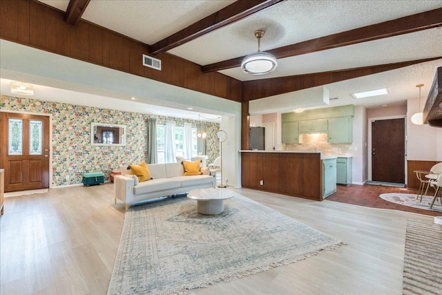 9011 W Pointer Ln, Austin, TX 78758 - living room with light wood-style flooring, wallpapered walls, beam ceiling, healthy amount of natural light, and baseboards