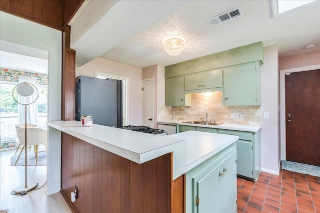 9011 W Pointer Ln, Austin, TX 78758 - kitchen with stainless steel appliances, light countertops, decorative backsplash, a peninsula, and a sink