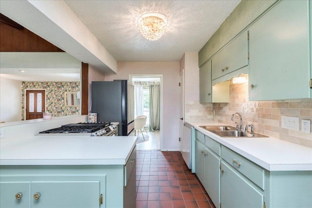 9011 W Pointer Ln, Austin, TX 78758 - kitchen with a sink, light countertops, freestanding refrigerator, decorative backsplash, and a textured ceiling