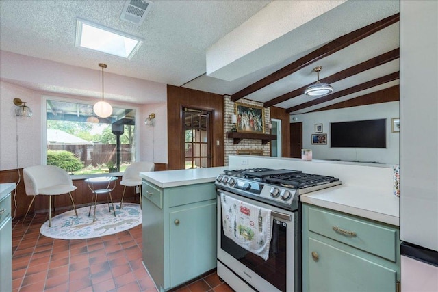 9011 W Pointer Ln, Austin, TX 78758 - kitchen with stainless steel gas stove, green cabinets, light countertops, a skylight, and a textured ceiling