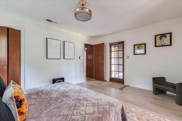 9011 W Pointer Ln, Austin, TX 78758 - bedroom with wood finished floors, a textured ceiling, and a closet