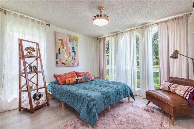 9011 W Pointer Ln, Austin, TX 78758 - bedroom featuring a textured ceiling and light wood-style floors
