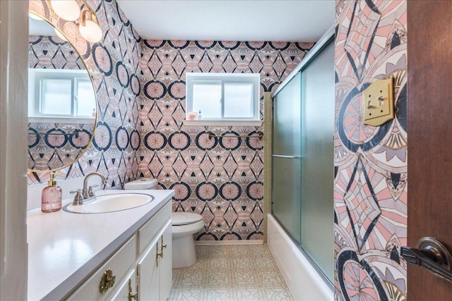 9011 W Pointer Ln, Austin, TX 78758 - bathroom with toilet, vanity, enclosed tub / shower combo, and wallpapered walls