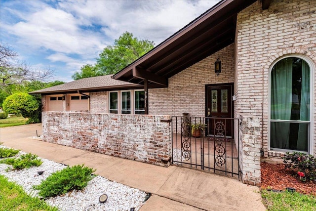 9011 W Pointer Ln, Austin, TX 78758 - property entrance with brick siding, a garage, and driveway