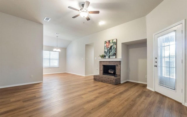 208 Bastian Ln, Georgetown, TX 78626 - unfurnished living room with a fireplace, ceiling fan, a chandelier, lofted ceiling, and wood finished floors