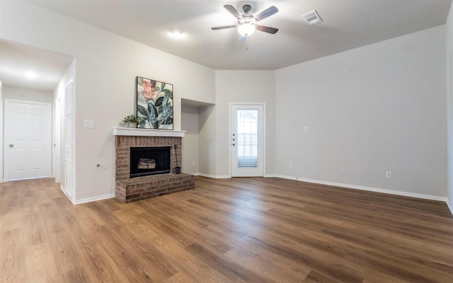 208 Bastian Ln, Georgetown, TX 78626 - unfurnished living room featuring a ceiling fan, a fireplace, wood finished floors, and baseboards