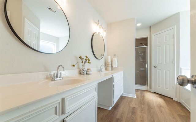 208 Bastian Ln, Georgetown, TX 78626 - bathroom with a shower stall, double vanity, and wood finished floors
