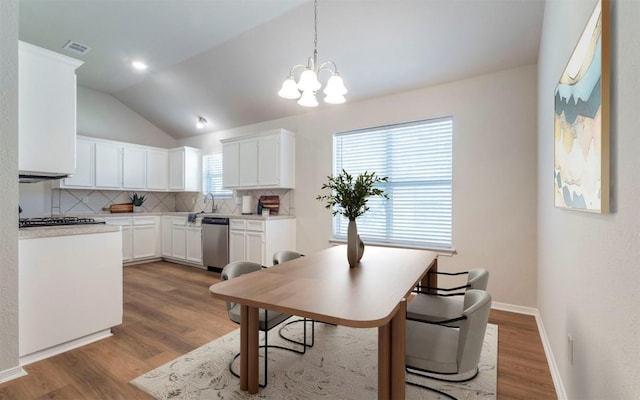 208 Bastian Ln, Georgetown, TX 78626 - dining room featuring lofted ceiling, wood finished floors, a chandelier, and baseboards