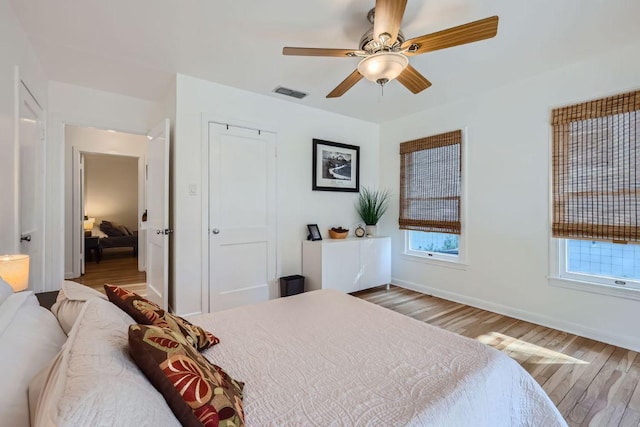 2102 E Martin Luther King Jr Blvd, Austin, TX 78702 - bedroom with wood finished floors, baseboards, ceiling fan, and a closet