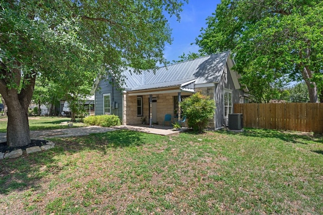 1503 Hart St, Georgetown, TX 78626 - rear view of house with central air condition unit, metal roof, and stone siding