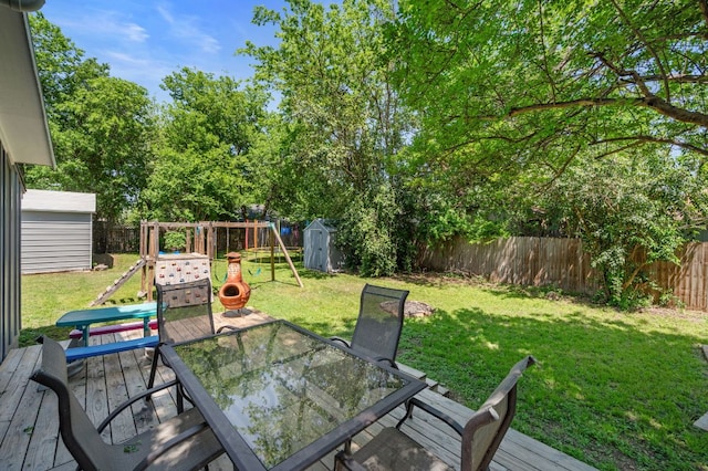 1503 Hart St, Georgetown, TX 78626 - wooden deck with a shed, outdoor dining area, a fenced backyard, and a playground