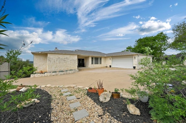3225 Eisenhower Ave, Lago Vista, TX 78645 - view of front of home featuring an attached garage, concrete driveway, and stone siding