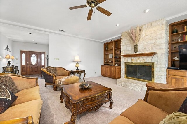 3225 Eisenhower Ave, Lago Vista, TX 78645 - living area featuring ceiling fan, light colored carpet, a stone fireplace, and ornamental molding