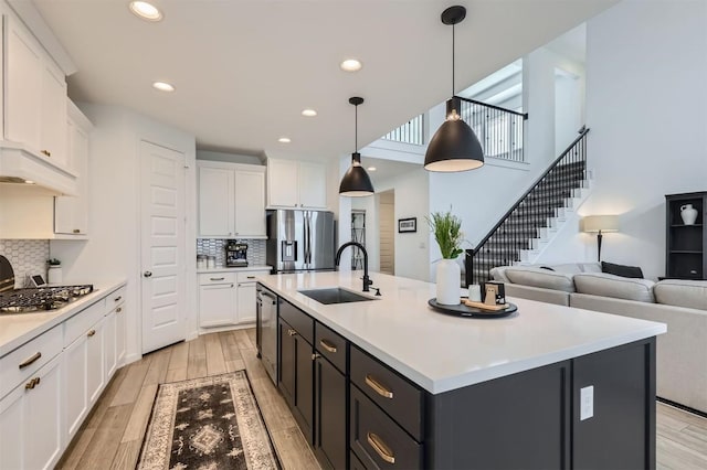 1205 Bluewood Bnd, Leander, TX 78641 - kitchen featuring appliances with stainless steel finishes, a sink, white cabinetry, light countertops, and recessed lighting