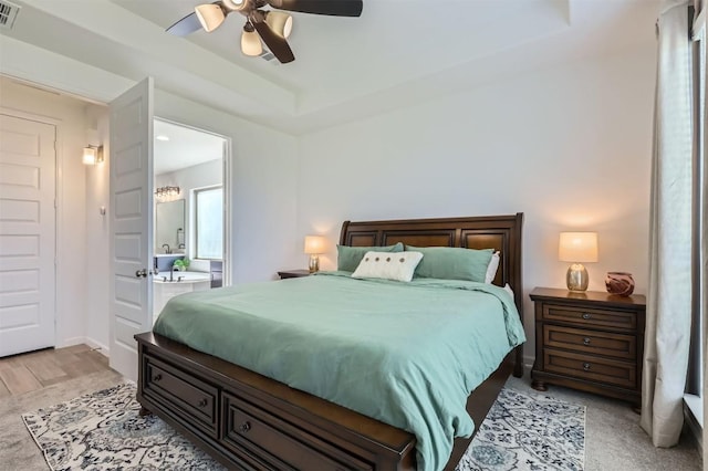 1205 Bluewood Bnd, Leander, TX 78641 - bedroom featuring ceiling fan, ensuite bath, light wood finished floors, and baseboards