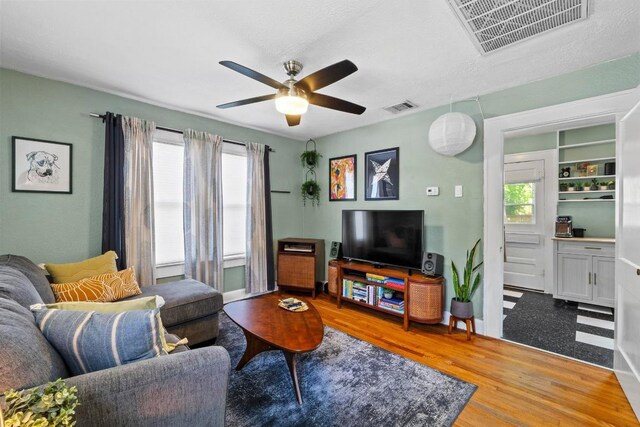 504 E 38th 1/2 St, Austin, TX 78751 - living room with a ceiling fan, plenty of natural light, wood finished floors, and baseboards