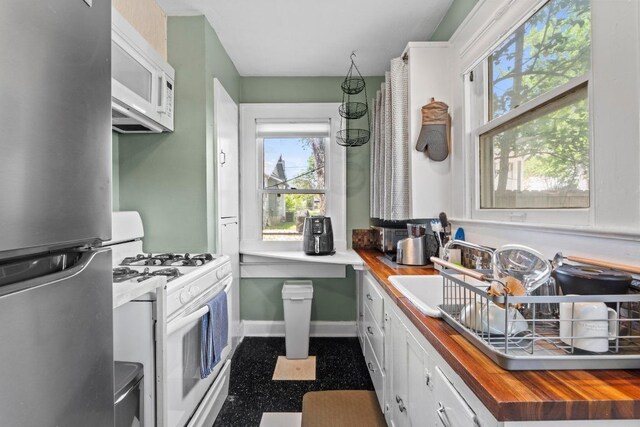 504 E 38th 1/2 St, Austin, TX 78751 - kitchen with white appliances, butcher block counters, white cabinetry, and a sink