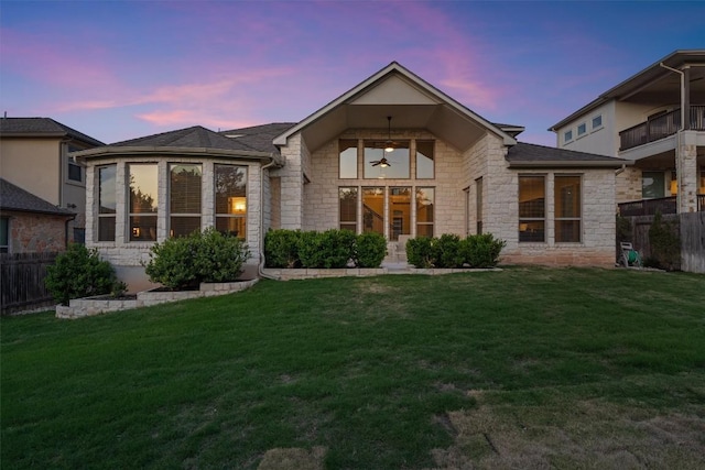 3912 Logan Ridge Dr, Cedar Park, TX 78613 - back of house featuring a lawn, ceiling fan, fence, and stone siding
