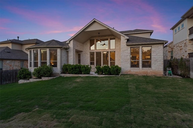 3912 Logan Ridge Dr, Cedar Park, TX 78613 - rear view of property featuring fence, ceiling fan, a yard, and stone siding