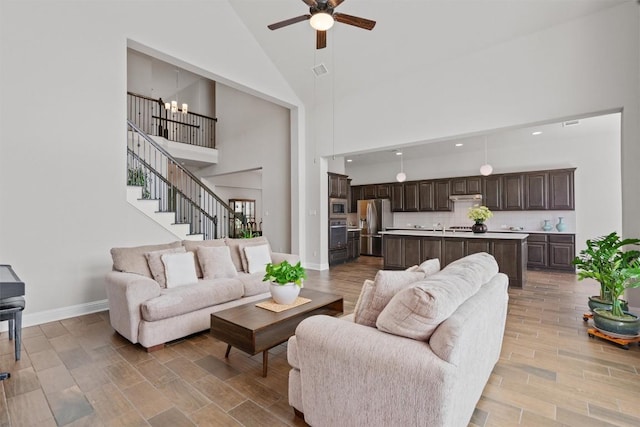 3912 Logan Ridge Dr, Cedar Park, TX 78613 - living room featuring high vaulted ceiling, light wood-style flooring, ceiling fan with notable chandelier, recessed lighting, and baseboards
