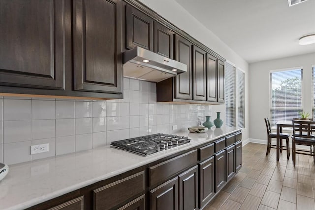 3912 Logan Ridge Dr, Cedar Park, TX 78613 - kitchen featuring baseboards, decorative backsplash, under cabinet range hood, and dark brown cabinets