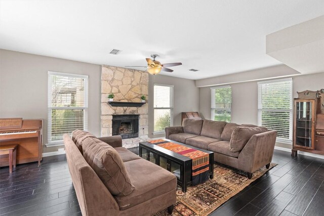 living area featuring dark wood-style floors, a ceiling fan, a fireplace, and baseboards