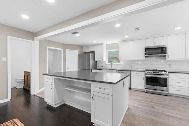 6551 Fair Valley Trl, Austin, TX 78749 - kitchen featuring appliances with stainless steel finishes, dark countertops, white cabinetry, backsplash, and recessed lighting