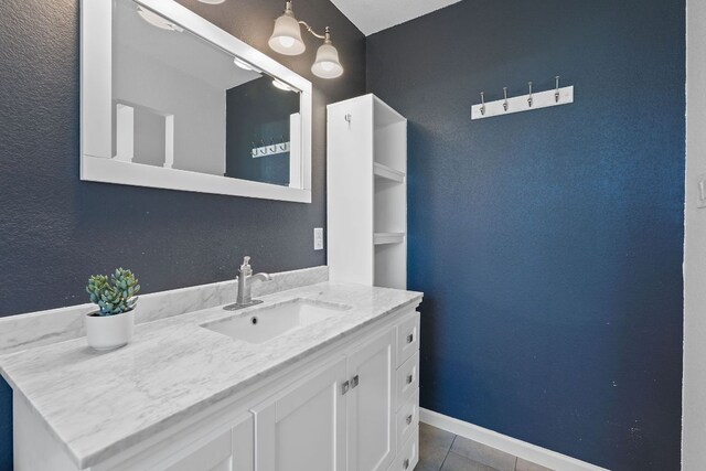 bathroom featuring tile patterned flooring, vanity, and baseboards