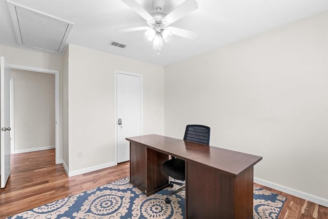 office featuring attic access, wood finished floors, baseboards, and ceiling fan